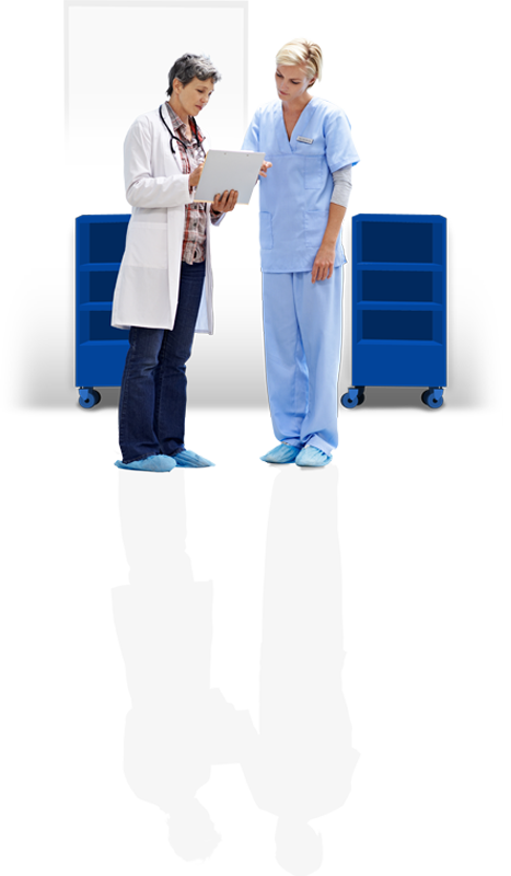 Ärztin hält ein Klemmheft vor sich in der Hand und zeigt darauf einer Arzthelferin mit hellblauem Anzug etwas.